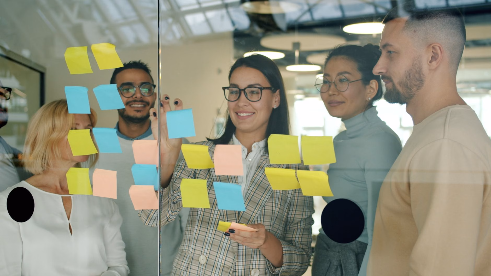 Équipe agile réunie debout autour d'un tableau pour la mêlée quotidienne