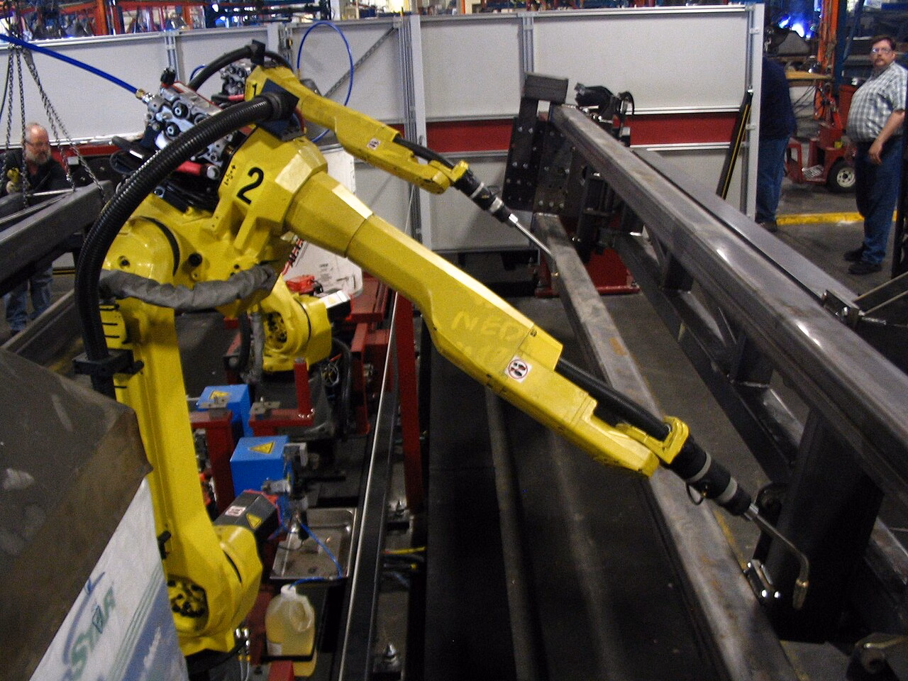 Bras robotiques industriels en action dans une usine automatisée.
